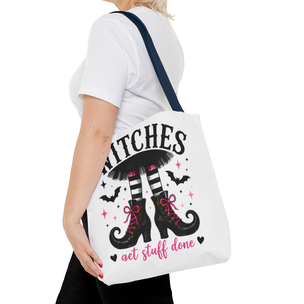 White tote bag on shoulder with witch boots graphic, bats, and “get stuff done”