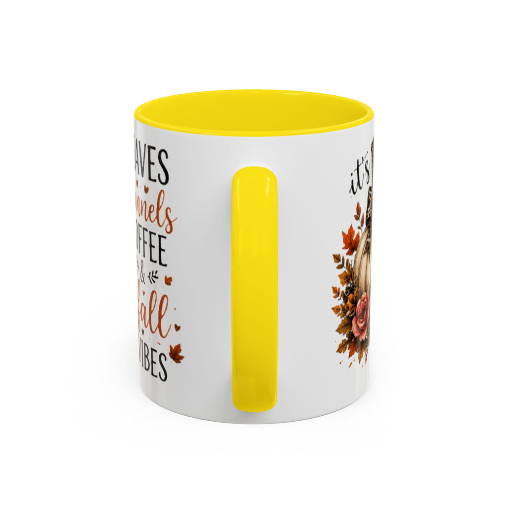 White coffee mug with yellow interior and handle, partial autumn text graphic on side