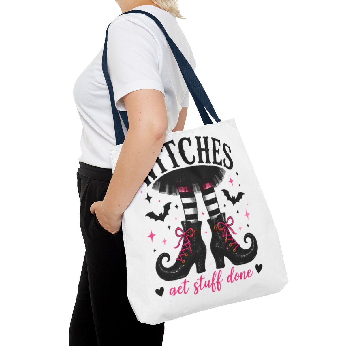 White tote bag on shoulder with witch boots graphic and “get stuff done” lettering