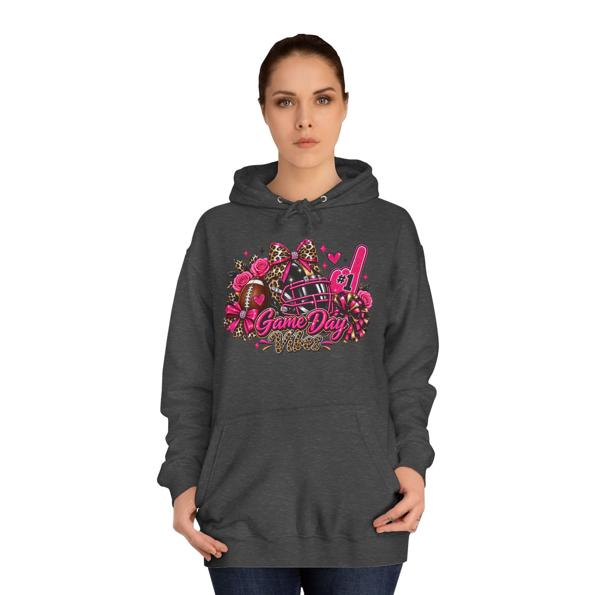 Game Day Cheer Hoodie — Pink Football Floral Design by Printify, dark gray hoodie with pink football, bows, flowers, pom poms, and Game Day graphic modeled by a woman