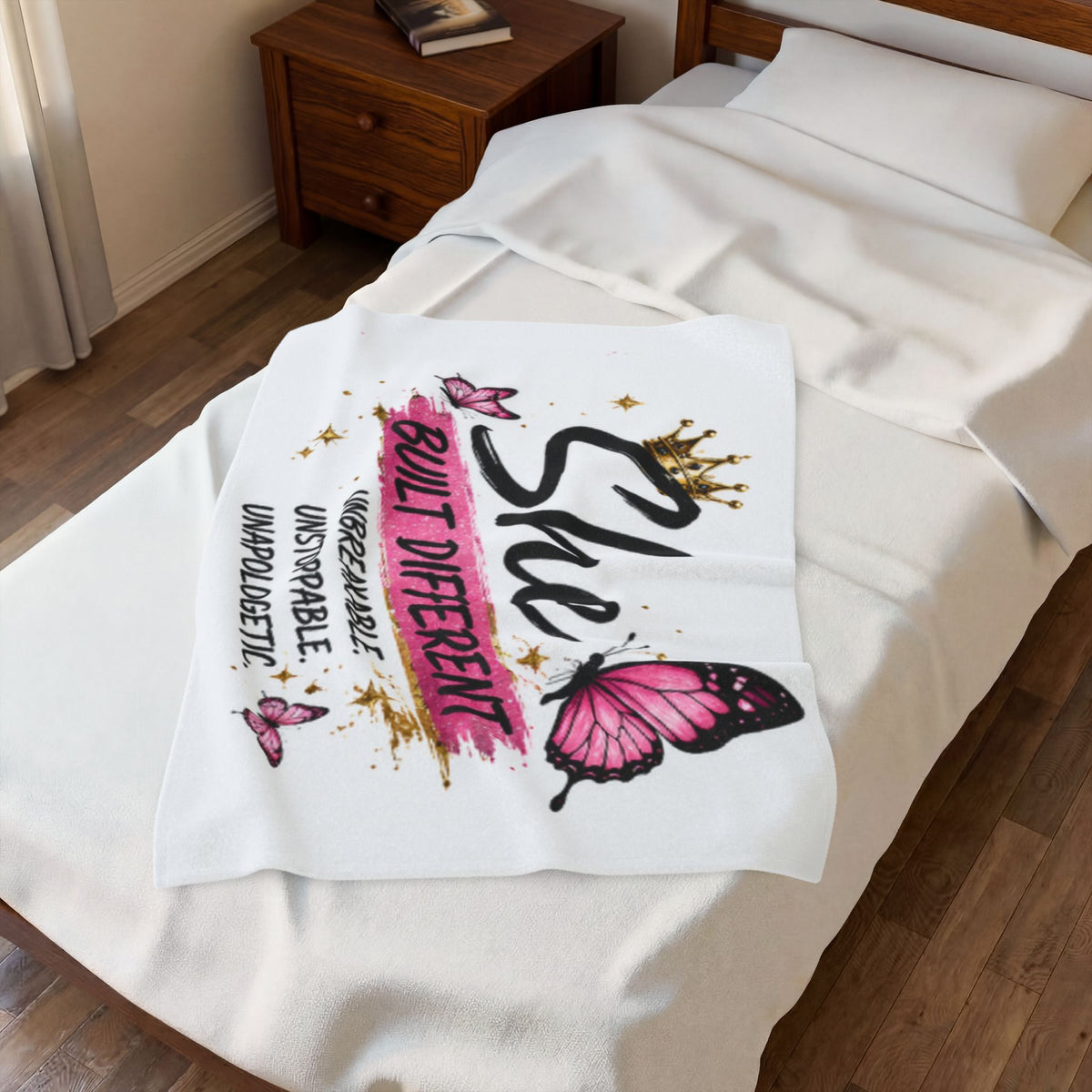 White velveteen plush blanket with pink butterflies and 'Built Different' graphic