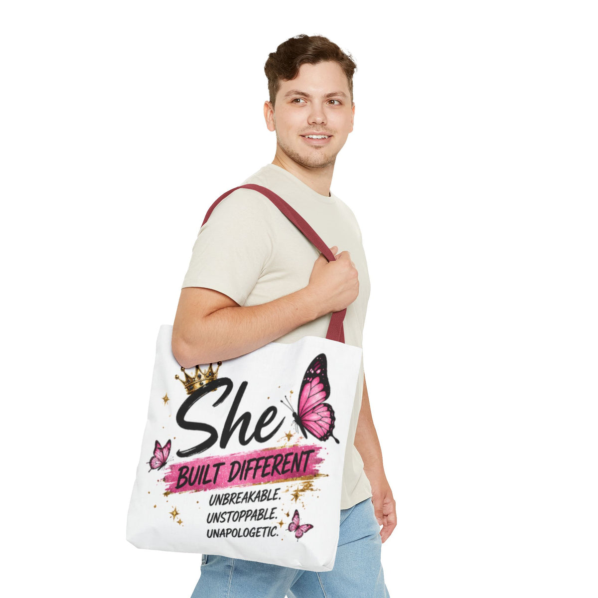 White tote bag with burgundy handles, butterfly “She Built Different” design on front.