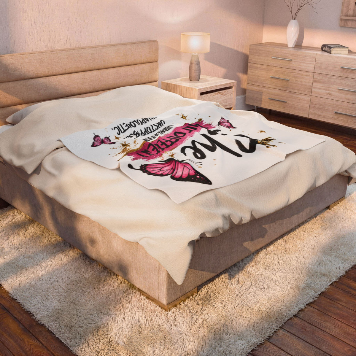 White plush blanket on bed with "Built Different" and pink butterfly design