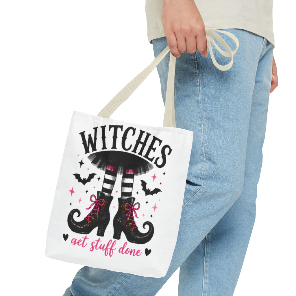 Cream canvas tote bag held by handles with witch legs graphic and 'WITCHES' text