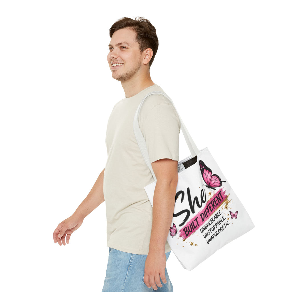 White tote bag with light gray handles, “She Built Different” butterfly graphic on side view.